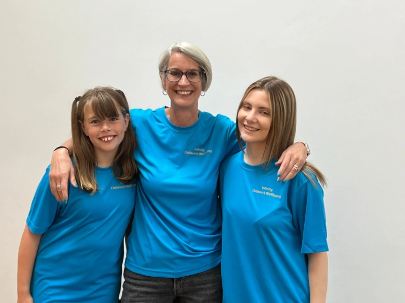 Natalie Bryden arm in arm with two assistant instructors